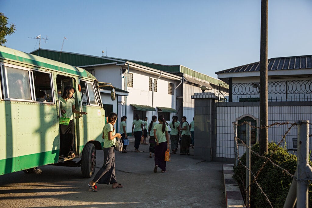A shuttle bus drops of workers at Charming Garment Manufacturing in Yangon's Hlaing Tharyar industrial zone.