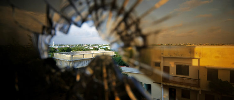 A view of the skyline beyond the northern suburbs of Mogadishu is seen through a bullet hole in the window of a hotel in the Yaaqshiid District of Mogadishu, where African Union Mission in Somalia (AMISOM) forces have pushed Al Shabaab militants beyond the city's northern fringes to the outskirts of the Somalia seaside.